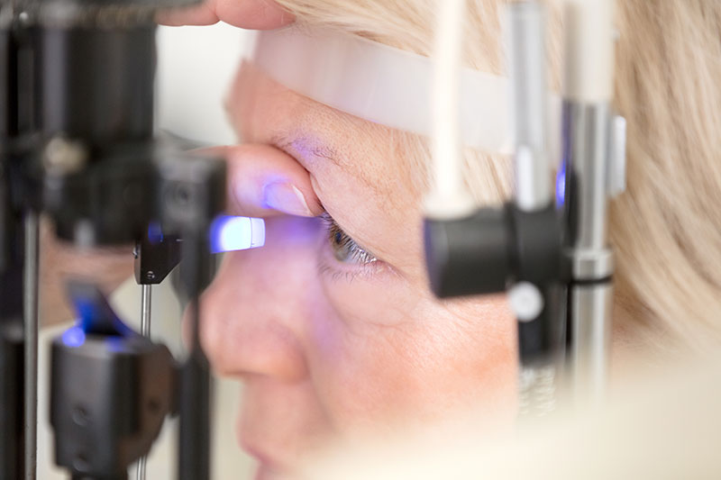 A woman's eye is being examined by an Eye doctor specializing in Eye care.