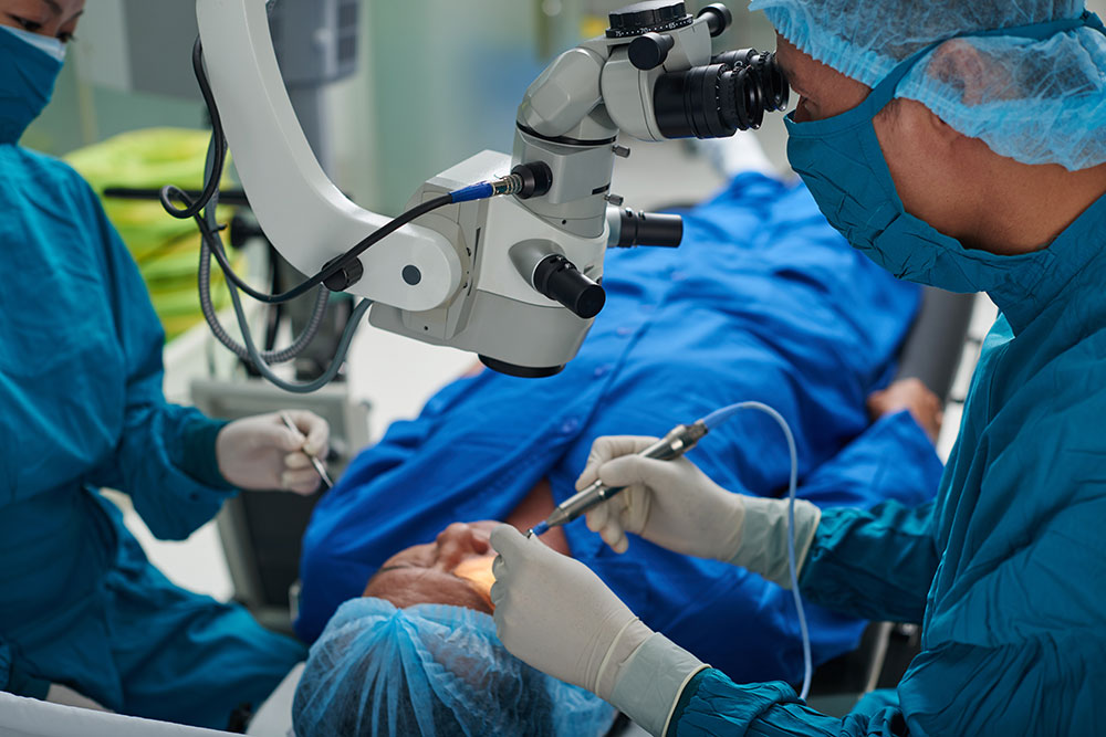 A surgeon, specialized in eye health, is operating on a patient in an operating room.