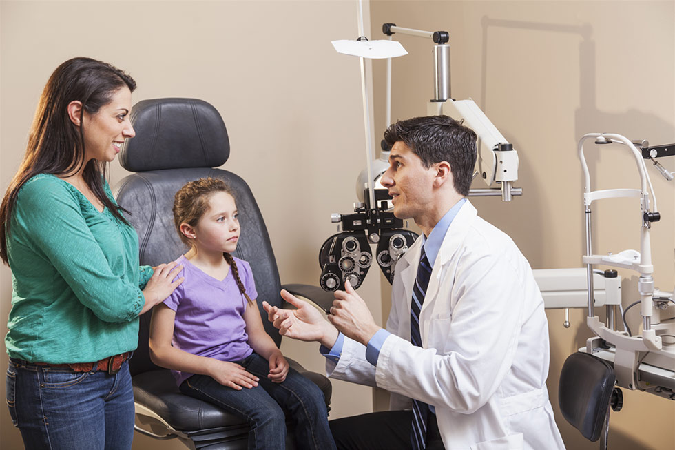 A woman and a child sitting in an eye doctor's office.