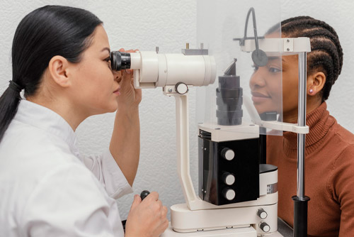 A woman is having her eyes examined by an optometrist, ensuring proper eye care.