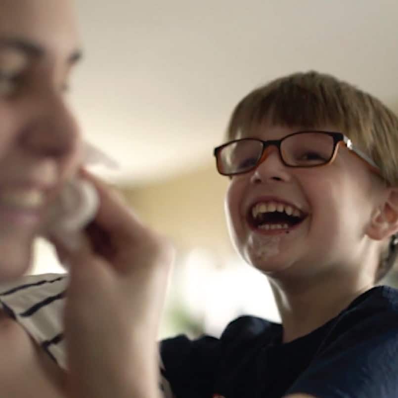 A with glasses is holding a child's hand.