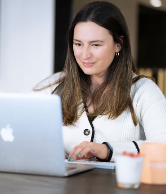 A woman meticulously typing on a laptop, prioritizing her eye care.