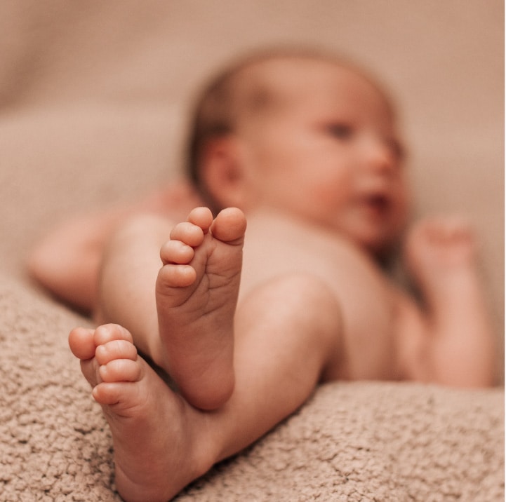 A baby's feet are peacefully rested on a soft blanket.